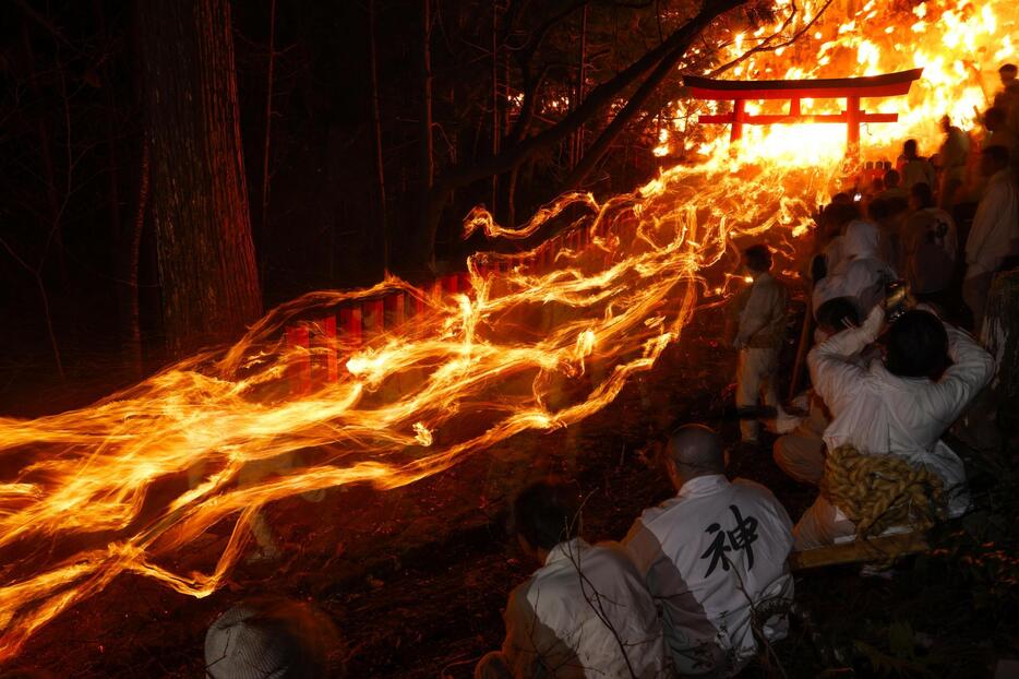 燃えさかるたいまつを手に男衆が参道を駆け降りる、神倉神社の伝統の火祭り「お灯まつり」＝6日夜、和歌山県新宮市（8秒間露光）