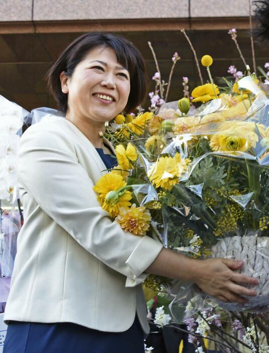 市職員から贈られた花束を手に笑顔を見せる前橋市の小川晶市長＝28日午前、前橋市役所