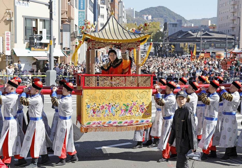 「長崎ランタンフェスティバル」で行われた「皇帝パレード」で、沿道に集まった人にみこしから手を振る歌手の福山雅治さん＝17日、長崎市