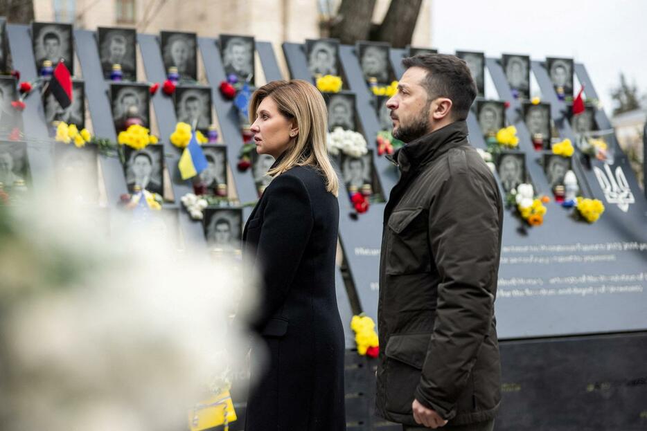 「マイダン革命」の犠牲者107人を追悼する式典で、妻オレナさんと共に慰霊碑を訪れたウクライナのゼレンスキー大統領＝20日、キーウ（ロイター＝共同）
