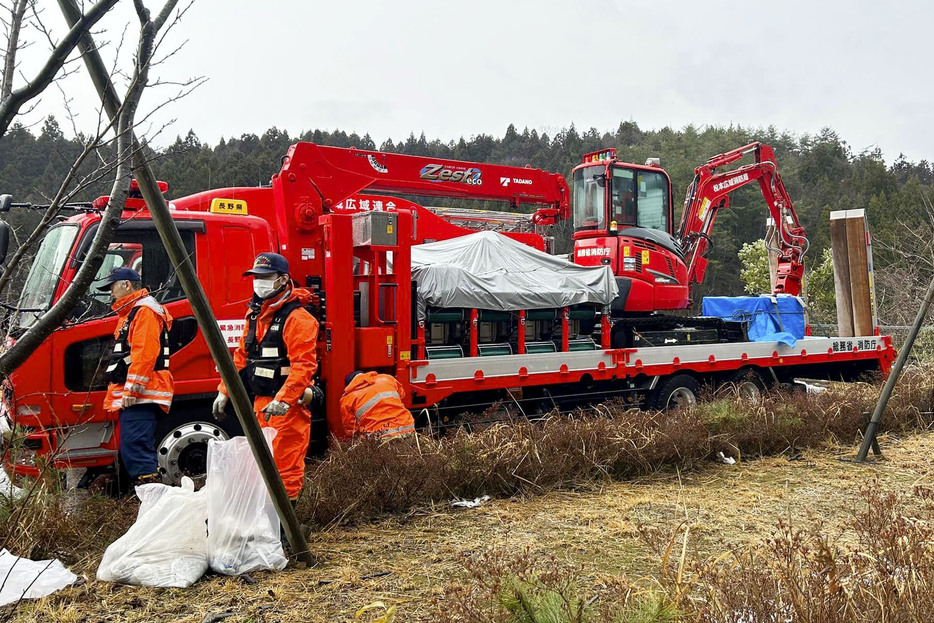 石川県珠洲市の緊急消防援助隊拠点に停車する重機（右）と重機搬送車＝1月（DRT―JAPAN提供）