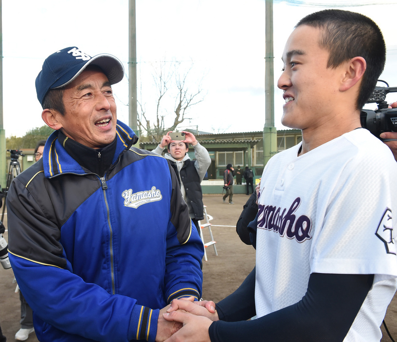 センバツ出場が決定し伊藤大惺主将と握手する村田治樹監督（左）＝三重県伊勢市黒瀬町の宇治山田商で２０２４年１月２６分、大竹禎之撮影