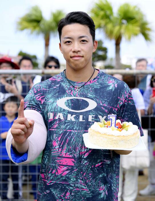 誕生日ケーキを手にポーズをとる中日・岡林＝北谷