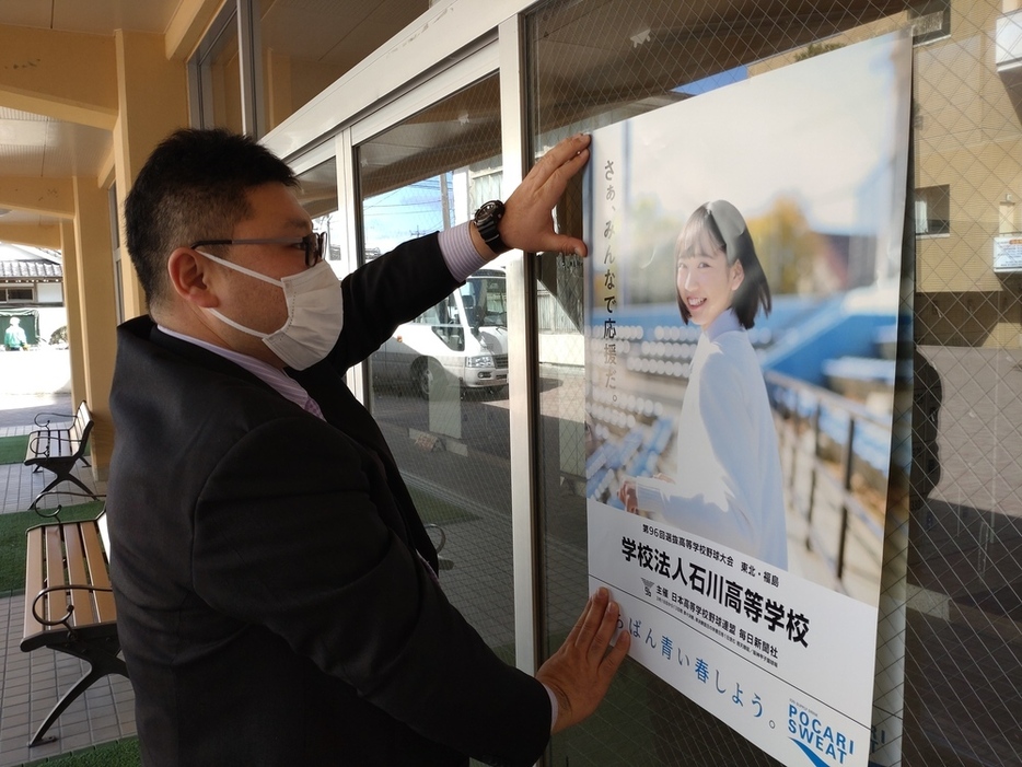 届いたばかりのセンバツ応援ポスターを校内に掲示する学法石川野球部の伊東美明部長＝福島県石川町の同校で２０２４年２月２８日、西川拓撮影