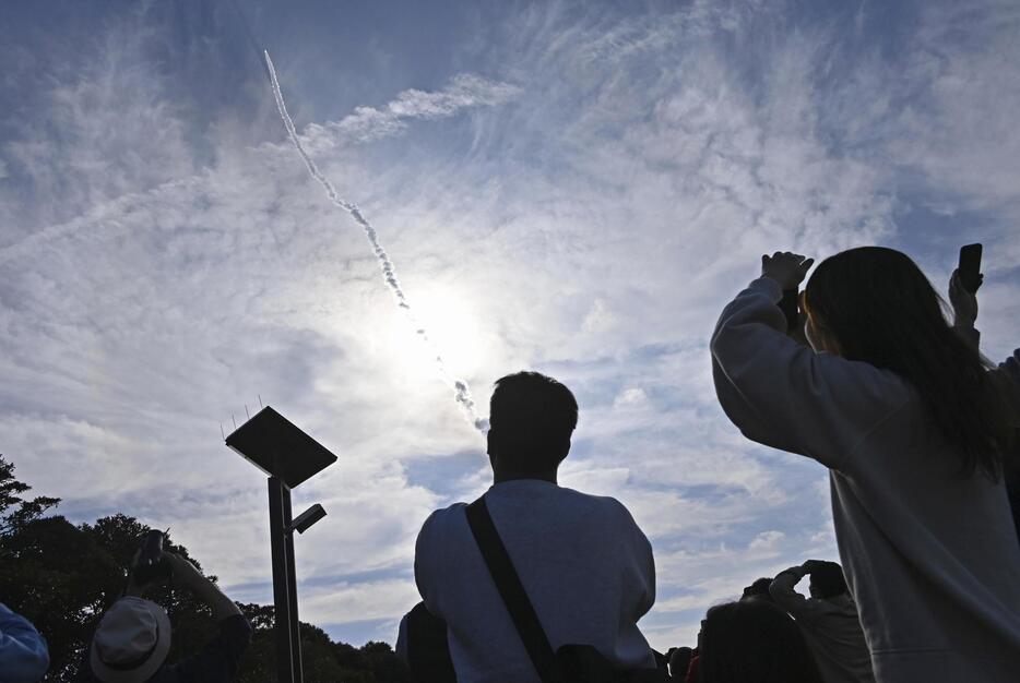 打ち上げられたH3ロケット2号機を見上げる人たち＝17日午前9時24分、鹿児島県南種子町