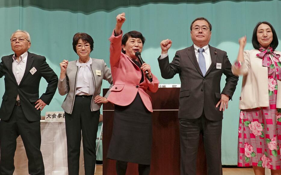 社民党の党大会で気勢を上げる福島党首（中央）ら＝24日午後、東京都内