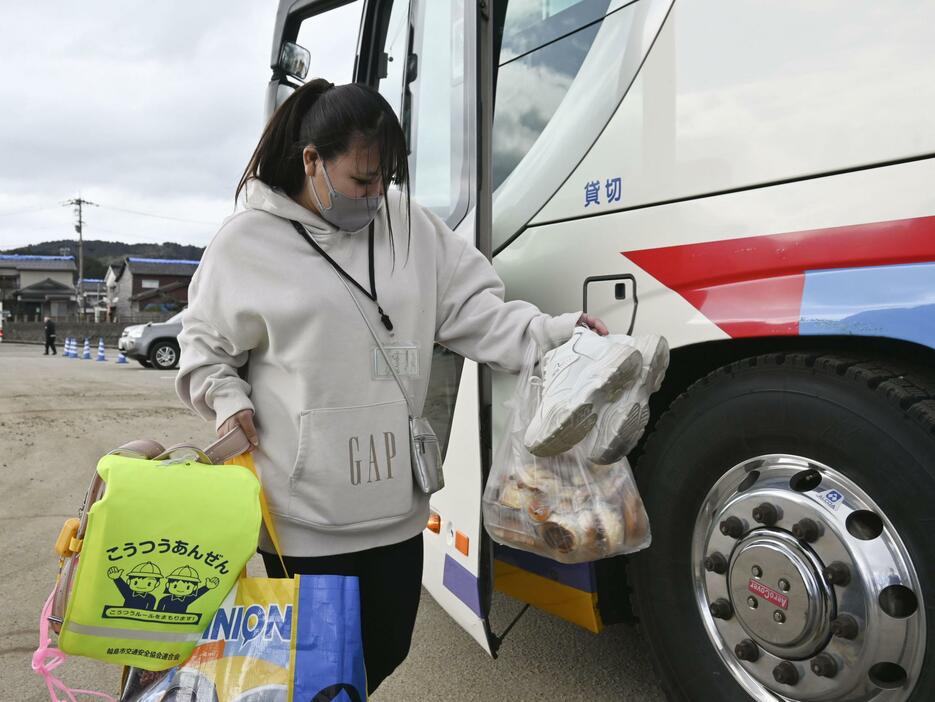 被災した石川県輪島市の自宅から持ち帰った娘のランドセルなどを手に、2次避難先に向かう沖崎雅さん＝24日午後