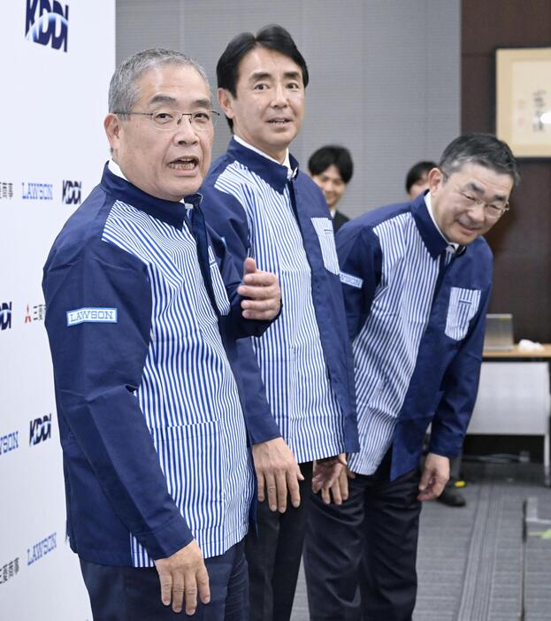 ローソンの制服を着て写真撮影に応じた（左から）三菱商事の中西勝也社長、ローソンの竹増貞信社長、KDDIの高橋誠社長＝6日午後、東京・丸の内