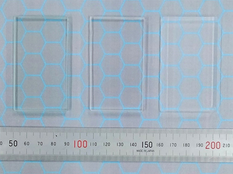 左から、窓などに使われる一般的な「並ガラス」、実験器具などの「白ガラス」、新たに開発したエアロゲル。ガラスに近い透明さを実現した（京都大学提供）