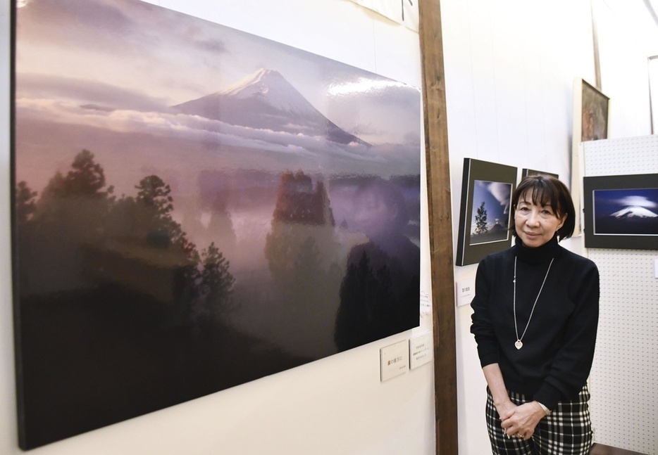 杉浦さんが撮影した富士山の写真の前で、撮影に応じる伊東郁乃さん＝2024年1月、群馬県草津町