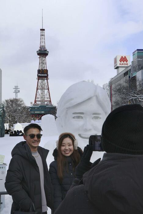 「さっぽろ雪まつり」最終日、大谷翔平選手の雪像の前で記念撮影をする人たち＝11日午後、札幌・大通公園