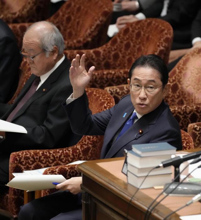 衆院予算委で答弁のため挙手する岸田首相＝26日午前