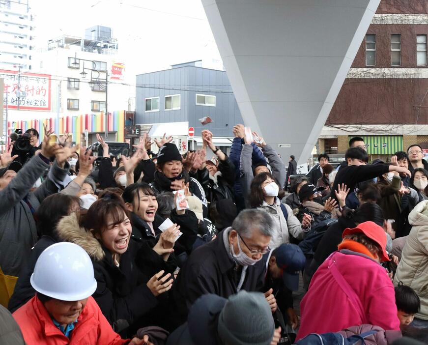 壇上からまかれた福豆の袋に手を伸ばす人々（撮影：具志堅浩二）