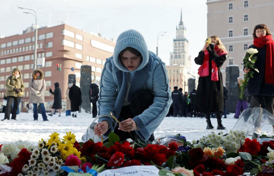 ロシアの反政府活動家ナワリヌイ氏の死を悼み、ろうそくに火をともす女性＝17日、モスクワ（ロイター＝共同）