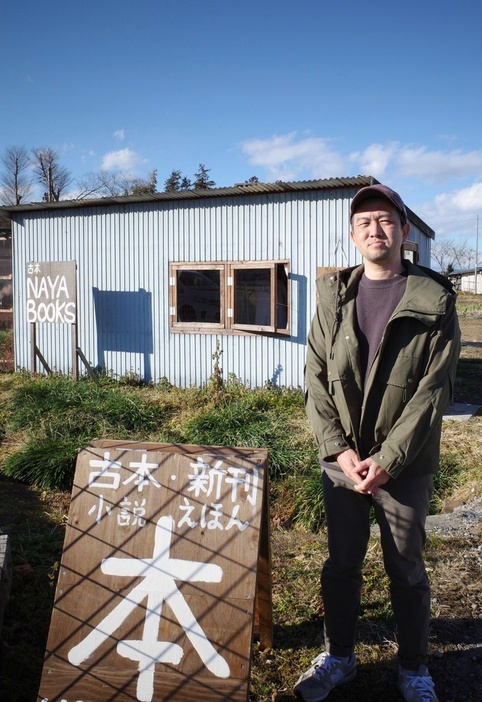 自宅の納屋を改装した「NAYA　BOOKS」の前に立つ高田直樹さん＝2024年1月、栃木県那須烏山市