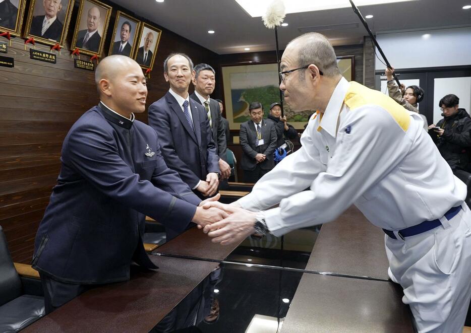 石川県輪島市の坂口茂市長（右）を表敬訪問し、握手を交わす日本航空高石川野球部の宝田一慧主将＝28日午後、輪島市役所