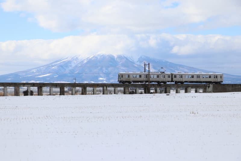 岩木山を背景に走る弘南鉄道の列車＝１月２７日、青森県平川市