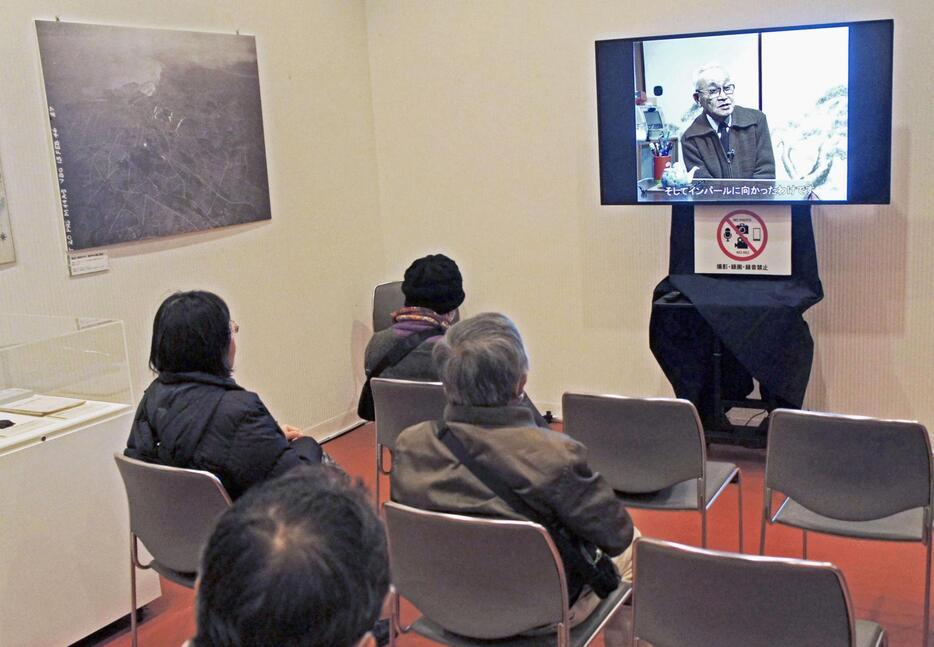 太平洋戦争の証言映像を見る来場者ら＝28日午前、東京・池袋の東京芸術劇場