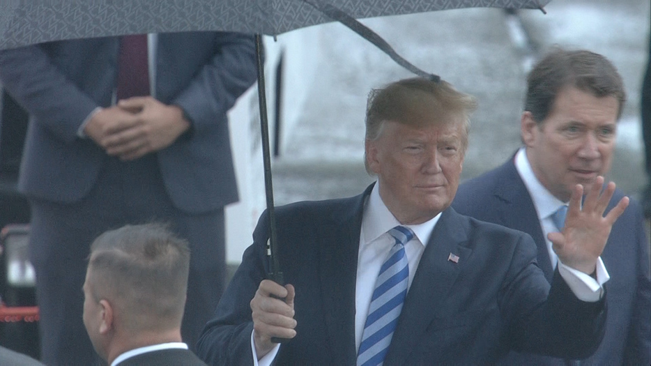 [画像] 大きな傘を手にタラップを降りたトランプ大統領＝27日午後6時50分ごろ