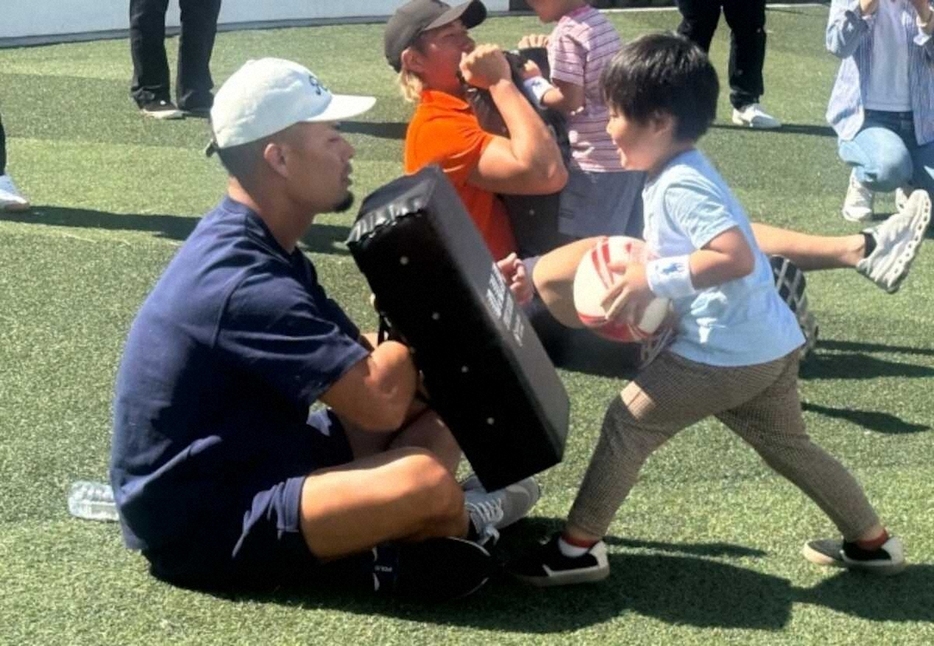 ラグビー教室で指導する田村（左）（所属事務所提供）