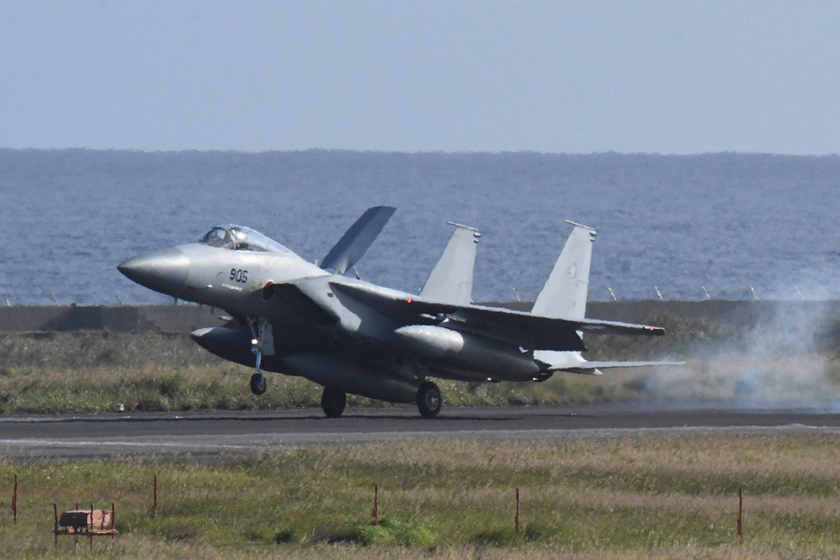 後輪だけ接地させ、すぐに飛び立つF15戦闘機＝27日午後3時15分ごろ、鹿児島県奄美市笠利町の奄美空港