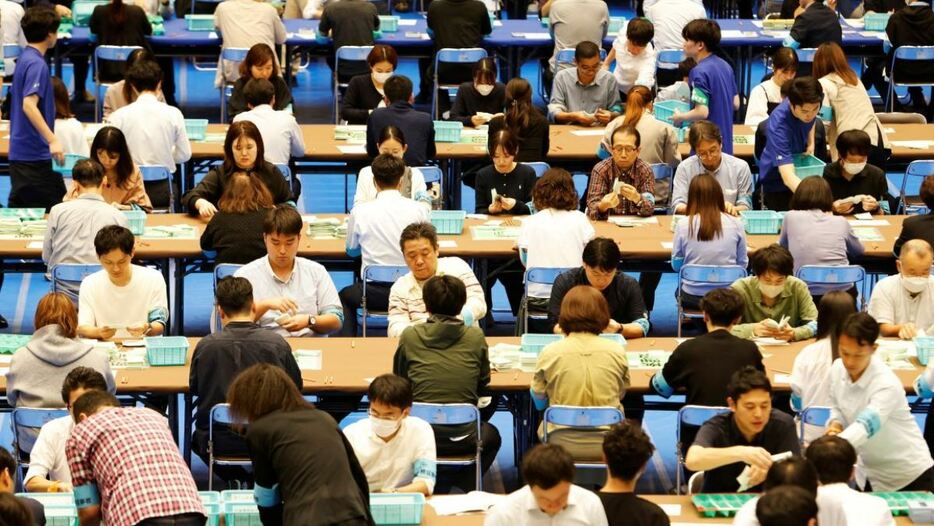 選挙管理委員会による開票作業の様子＝２７日、東京都内