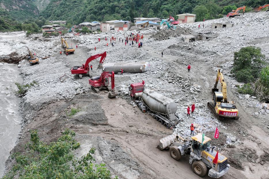 １０月２２日、 中国では自然災害による直接的な経済損失が第３・四半期に２３００億元（３２３億ドル）と、上半期の２倍以上に達した。写真は８月、四川省康定市の鉄砲水の被害現場で、道路の復旧作業にあたる作業員（２０２４年　ロイター／cnsphoto）