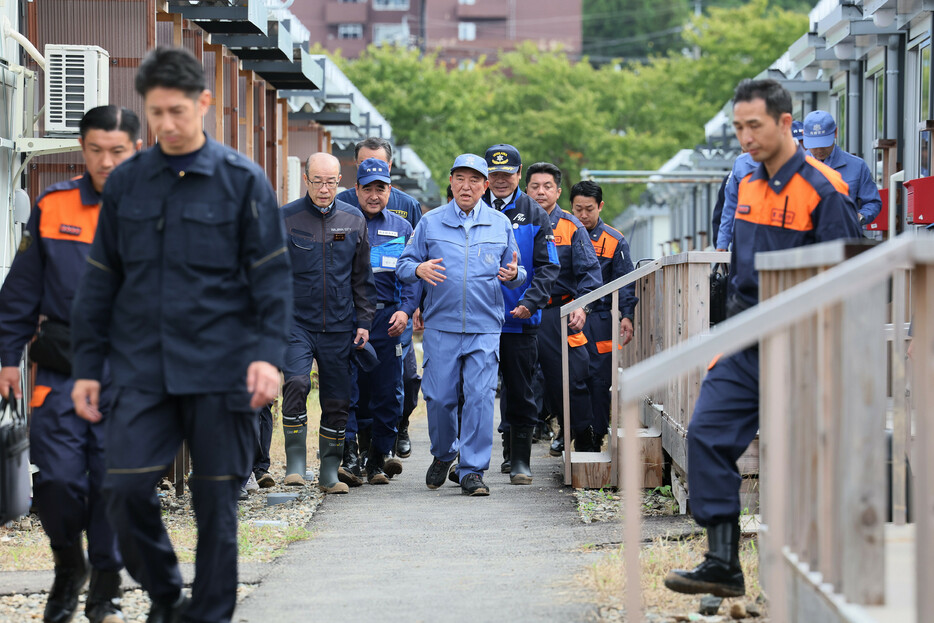 大雨で浸水した仮設住宅を視察する石破茂首相（中央）＝５日午前、石川県輪島市