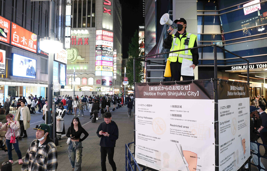 歌舞伎町で路上飲酒規制について呼び掛ける男性＝３１日午後、東京都新宿区