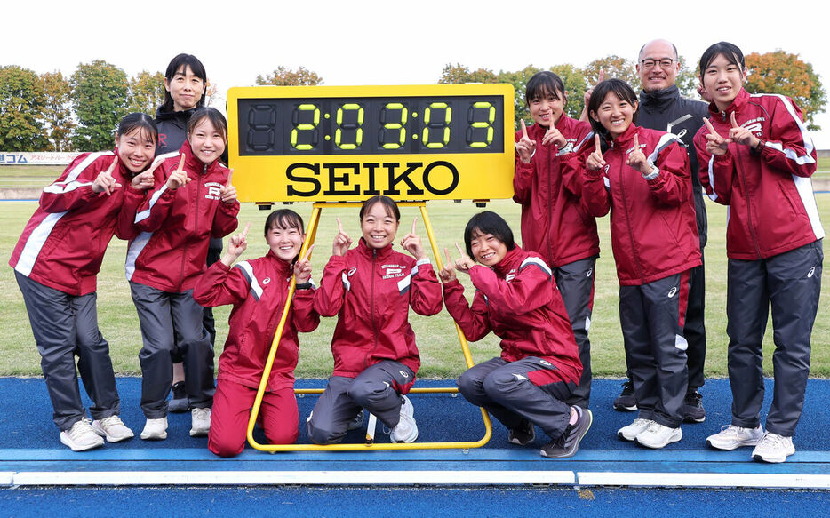 総合タイムを表した電光掲示の前でポーズをとる立命大（カメラ・関口　俊明）