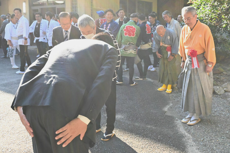 地元の祭り参加者に深くお辞儀し支持を求める立候補予定者＝12日午前8時10分ごろ、県内