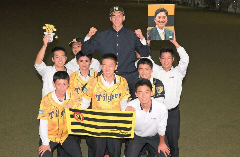 阪神からドラフト2位指名を受け、チームメートと写真におさまる報徳学園・今朝丸裕喜（中央）　＝報徳学園高校（撮影・根本成）