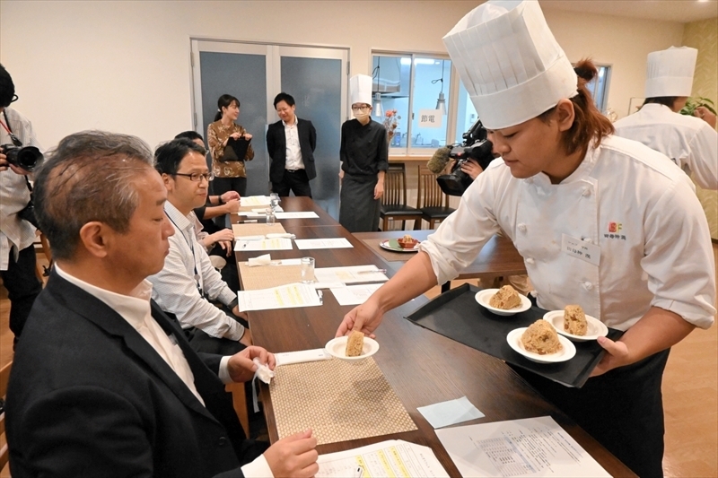 考案したおにぎりを提供する学生（右）