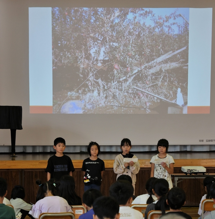 被災当時の写真を映し、学習発表する児童たち