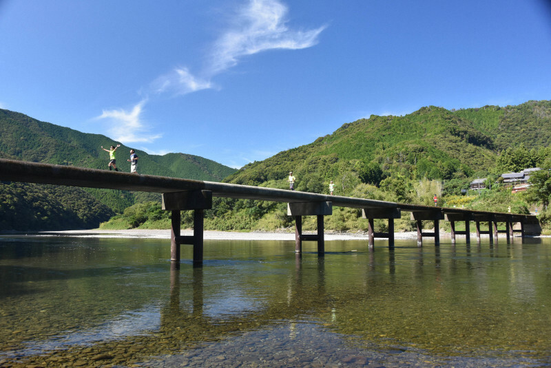 四万十川に架かる橋を走り抜けるランナー＝高知県四万十市岩間の岩間沈下橋で2024年10月20日午後0時14分、上野力撮影