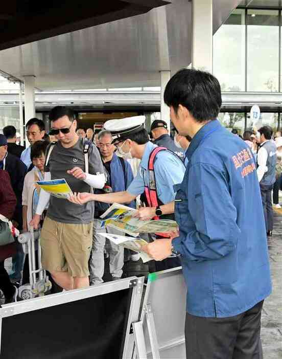 訪日客に「白タク」を使わないよう呼びかける八代署員と九州運輸局の職員＝5日、八代市