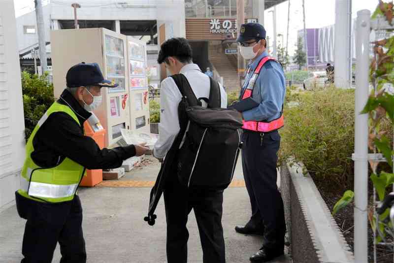 啓発チラシを配る大津地区地域交通安全活動推進委員ら＝29日、菊陽町