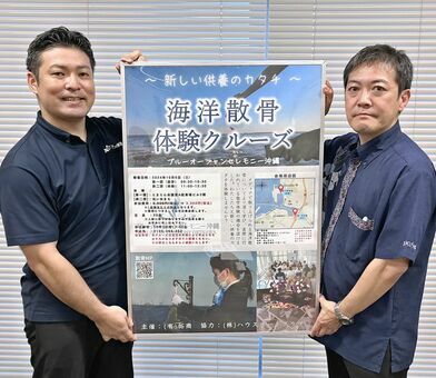 海洋散骨体験クルーズに参加を呼びかける拓商の親泊元隆副社長（左）と池宮城秀樹葬祭部長＝９月３０日、沖縄タイムス社