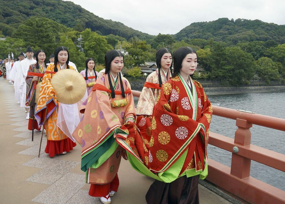 平安装束をまとい越前への旅を再現した行列。先頭が紫式部役の女性＝18日午前、京都府宇治市