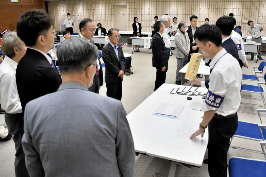 立候補受付順などの抽選を見守る代理人ら＝10月15日、福井県庁