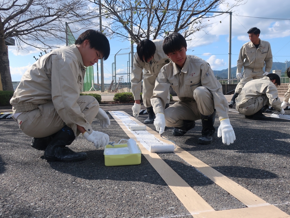 駐車場の白線引きに取り組む高校生=岡山県津山市で