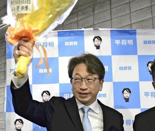 当選確実となり、花束を掲げる平将明さん