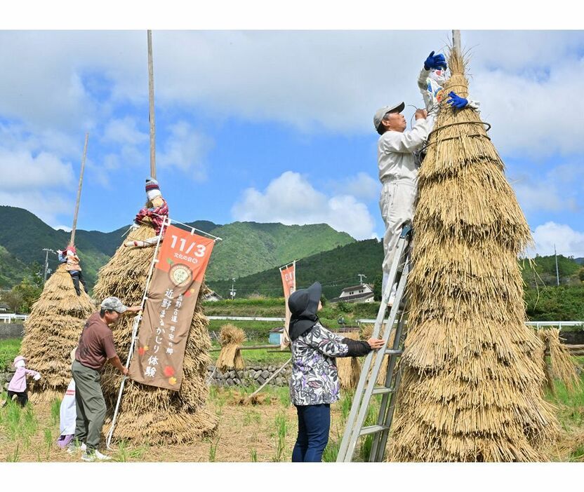 「わら塚」にかかしを飾り付ける関係者（和歌山県田辺市中辺路町で）