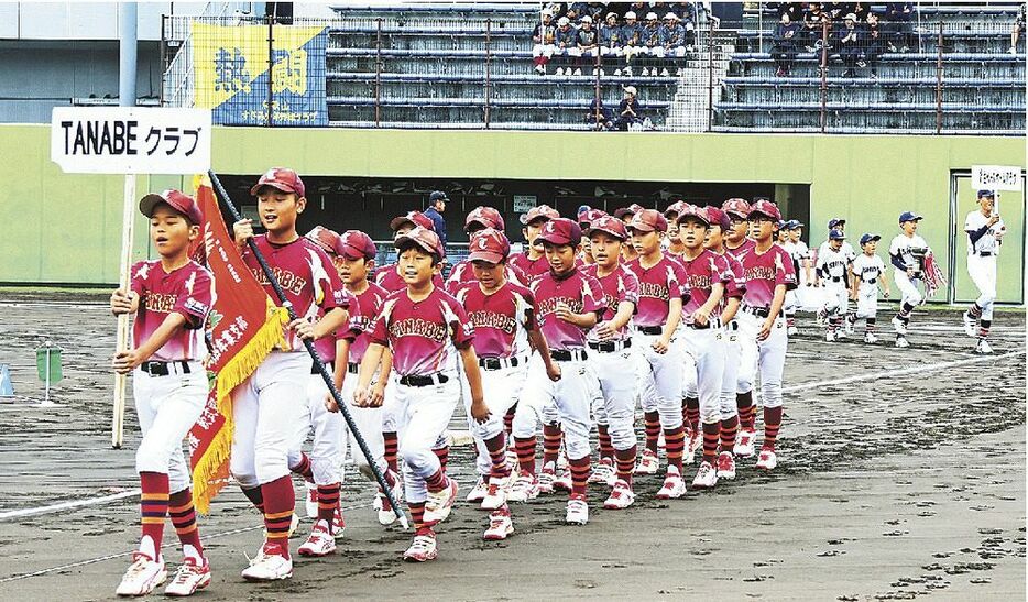 開会式で入場行進をする学童野球チームの児童（２６日、和歌山県田辺スポーツパーク野球場で）