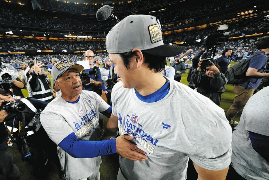 ナ・リーグ優勝決定シリーズを制し、大谷翔平（右）と言葉をかわすロバーツ監督（AP）