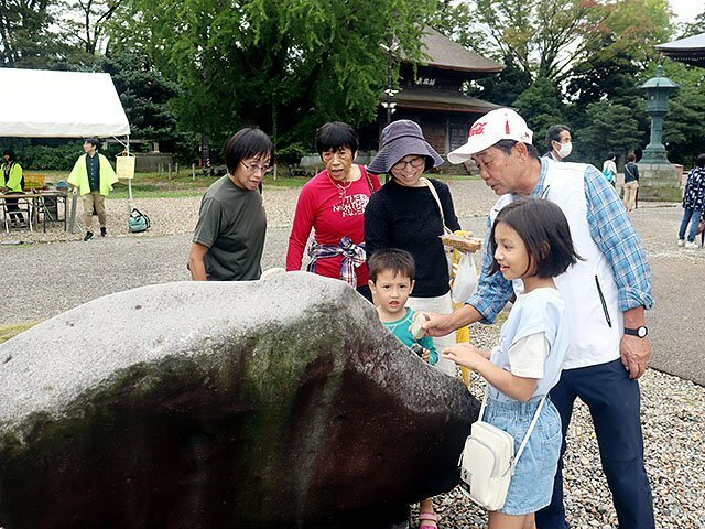 七不思議の一つ「天から降った石」に触れる来場者