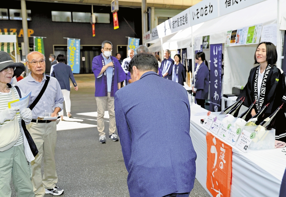 衆院解散後初の週末を迎え、イベント会場で市民らにあいさつする立候補予定者（中央）（12日、福岡県内で）＝秋月正樹撮影