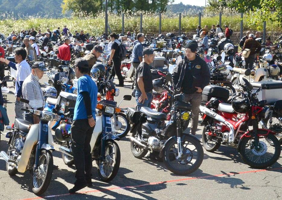 駐車場を埋め尽くすほど並んだスーパーカブなどの小型バイク＝魚沼市干溝