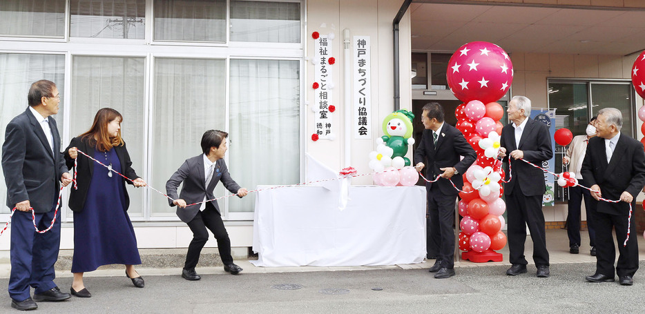 看板を除幕する関係者ら ＝垣鼻町の神戸地区市民センターで