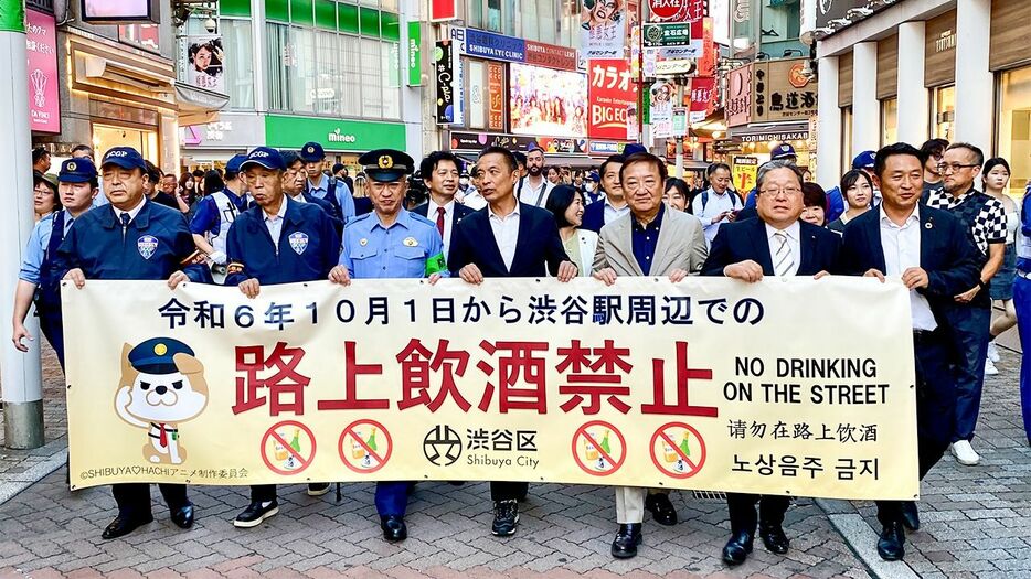 路上飲酒禁止を訴えるイベントで、横断幕を手にして渋谷センター街を歩く渋谷区の長谷部健区長（中央）ら＝2024年10月1日（筆者撮影）